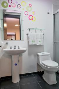 Un baño con lavabo, inodoro y espejo. en Hotel Volare, en Armenia
