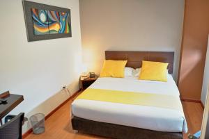 a bedroom with a large bed with yellow pillows at Hotel Volare in Armenia
