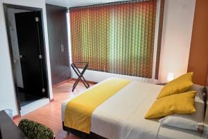 a bedroom with a large bed and a large window at Hotel Volare in Armenia