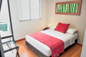 a bedroom with a bed with a red blanket at Hotel Volare in Armenia