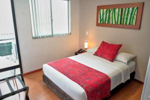 a bedroom with a large bed with a red pillow at Hotel Volare in Armenia