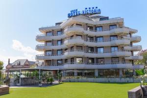 a hotel building with a lawn in front of it at Gran Hotel Victoria in Santander