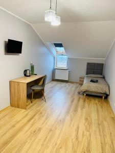 een slaapkamer met een bureau en een bed in een kamer bij Apartamenty Route 65 