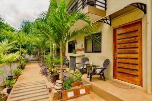 a house with a courtyard with palm trees and a wooden door at Tamarindo Sunshine in Tamarindo