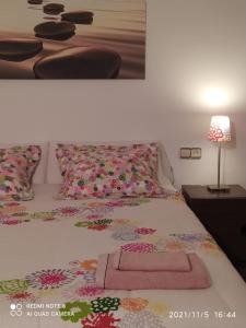 een bed met een roze deken en een lamp op een tafel bij Alojamiento Ronda San Juan in Riópar