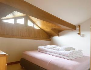 sypialnia na poddaszu z łóżkiem i świetlikiem w obiekcie Front de Neige de St Martin de Belleville - Appartement 60 m2 - 8 personnes - Residence Les Murgers w mieście Saint-Martin-de-Belleville