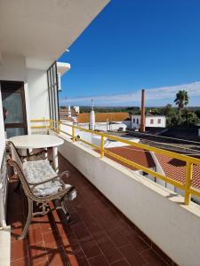 a balcony with a table and a view of the ocean at Algarve Apartment Manta Rota in Vila Nova de Cacela