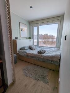 una camera con un letto e una grande finestra di Cozy house with sauna by the lake a Lokuti