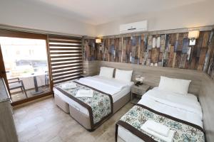 a small room with two beds and a window at Street61 Apart Hotel in Sarigerme