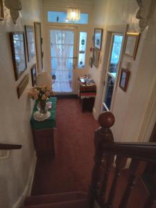a hallway of a house with a table and a window at Applebys Guest House in Holyhead