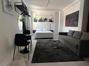 uma sala de estar com um sofá e uma cama em Eneldo modern & luxury em Málaga