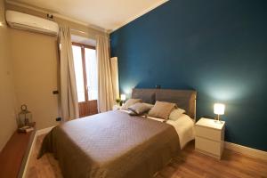 sypialnia z dużym łóżkiem z niebieską ścianą w obiekcie Red - Porta Romana APT - Dolcevita Holiday we Florencji