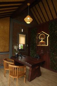 Licin的住宿－Kayon Griya Osing Villa - Ijen，一间带木桌和两把椅子的用餐室