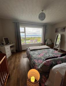 a bedroom with two beds and a large window at Rosie's Cottage in Moville