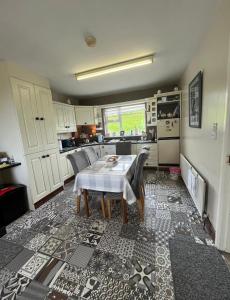 a kitchen with a table and chairs in a room at Rosie's Cottage in Moville