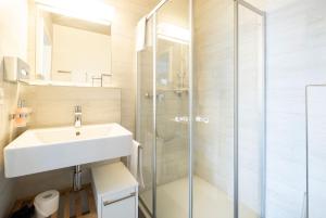 un bagno con lavandino e doccia di Tailormade Hotel IDEA Spreitenbach a Spreitenbach