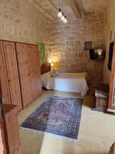 a bedroom with a bed and a rug in a room at Cozy 1 Bedroom House in Iz-Zejtun in Żejtun