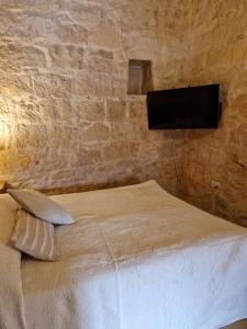 a bedroom with a bed with a tv on the wall at Cozy 1 Bedroom House in Iz-Zejtun in Żejtun