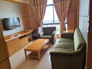 a living room with a couch and a table and a tv at Hotel Express in Luanda