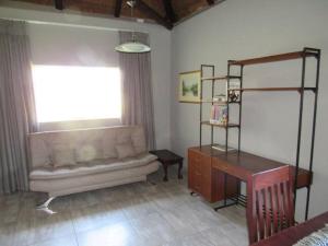 a living room with a couch and a desk and a window at Lions Rest on Vaal River in Vanderbijlpark