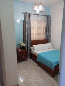 ein Schlafzimmer mit einem Bett, einem Tisch und einem Kronleuchter in der Unterkunft MH - Ground Floor Apart in New Bell
