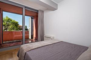 een slaapkamer met een bed en een groot raam bij Luxury City Center Apartment -50m to the sea in Opatija