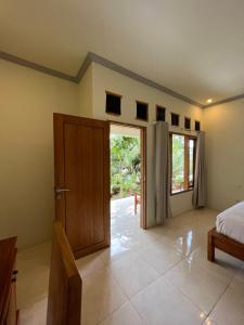 a bedroom with a door and a bed and a window at Kuta Circle Homestay in Kuta Lombok