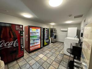 Motel 6-Greensboro, NC - Airport في جرينسبورو: غرفة بها جهازين كوكاكولا ومطبخ