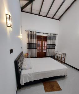 a bedroom with a large bed in a room at Niro Home Kamburugamuwa in Kamburugamuwa