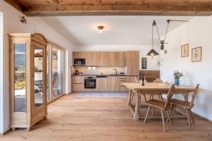 フューゲンにあるLottis Dahuamのオープンキッチン(木製テーブル、椅子付)