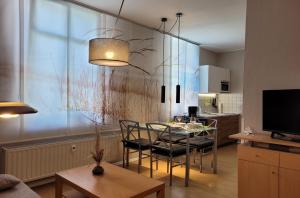 Una sala de estar con mesa y sillas y una cocina. en Ferienwohnung Strandburg, en Heringsdorf