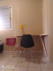 a desk in a room with a chair and a lamp at 3 Quartos da UFU in Uberlândia