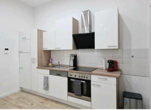 a kitchen with white cabinets and a stove top oven at Ihr zu Hause auf Zeit! in Solingen