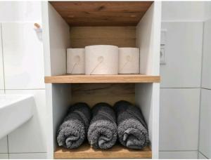 ein Regal mit Handtüchern und Handschuhen im Bad in der Unterkunft Ihr zu Hause auf Zeit! in Solingen