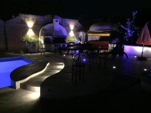 a patio with a table and chairs at night at Colours - a sweet complex in a fairytale setting in Ix-Xgħajriet