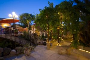 a patio with trees and lights at night at Colours - a sweet complex in a fairytale setting in Ix-Xgħajriet