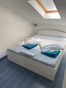 a white bed with blue pillows in a room at Apartments Tereza in Milna