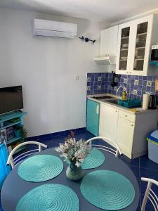 a kitchen with a table with four chairs and a kitchen with a counter at Apartments Tereza in Milna