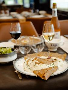 een tafel met een bord eten en een glas wijn bij La Marinière Hôtel Restaurant Crêperie in Saint-Malo