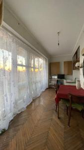 a living room with white curtains and a table at Квартира в Агудзере in Agudzera