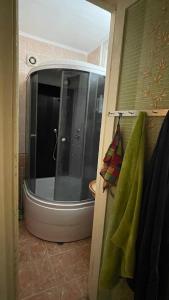 y baño con ducha y puerta de cristal. en Квартира в Агудзере, en Agudzera