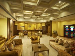 una gran sala de estar con sofás y una mesa. en Club Mahindra Kumbhalgarh, en Kumbhalgarh