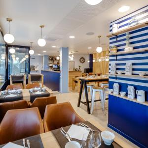 een restaurant met blauwe muren en houten tafels en stoelen bij La Marinière Hôtel Restaurant Crêperie in Saint-Malo