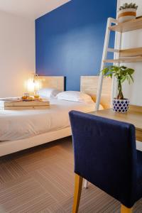 een slaapkamer met een bed, een stoel en een ladder bij La Marinière Hôtel Restaurant Crêperie in Saint-Malo