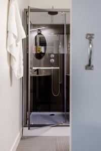 a shower with a glass door in a bathroom at La Marinière Hôtel Restaurant in Saint Malo