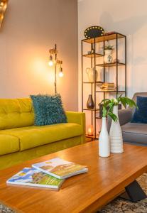 a living room with a yellow couch and a coffee table at The Good House - Harman in Hărman