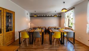 uma fila de mesas numa sala com cadeiras amarelas em The Good House - Harman em Hărman