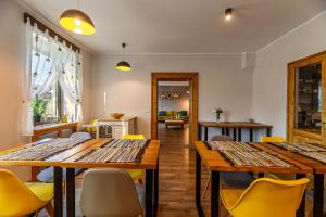 a dining room with wooden tables and yellow chairs at The Good House - Harman in Hărman