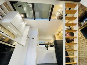 an open kitchen with white cabinets and a staircase at Studio Apartment in the heart of Aalborg in Aalborg