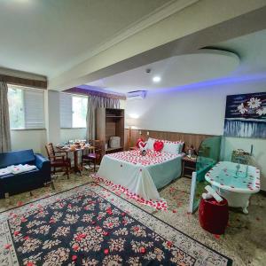 a room with a bed and a table and a couch at Hotel Dan Inn Campos do Jordão in Campos do Jordão